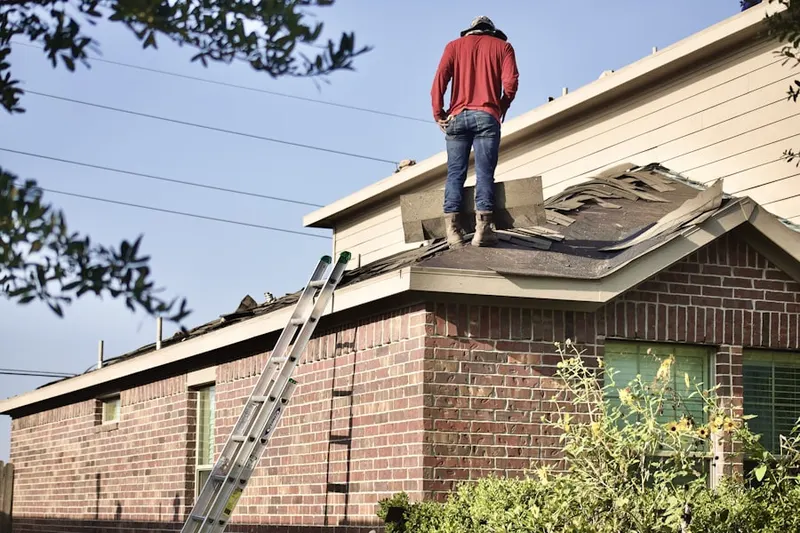 Professional roofer working on a residential roof in Gardenville Center